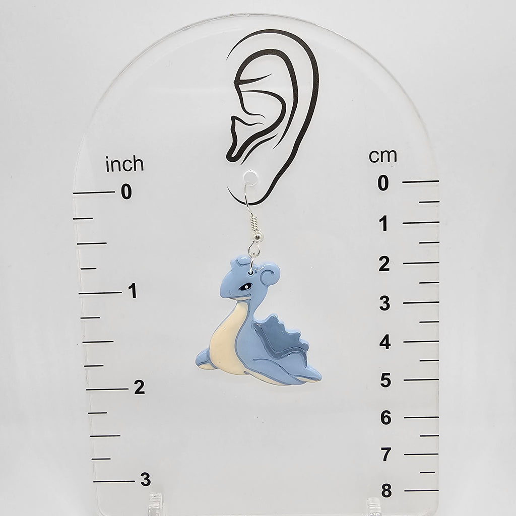 Dangle lapras earrings on a measuring device showing the earrings hang 2in from ear lobe hole. 