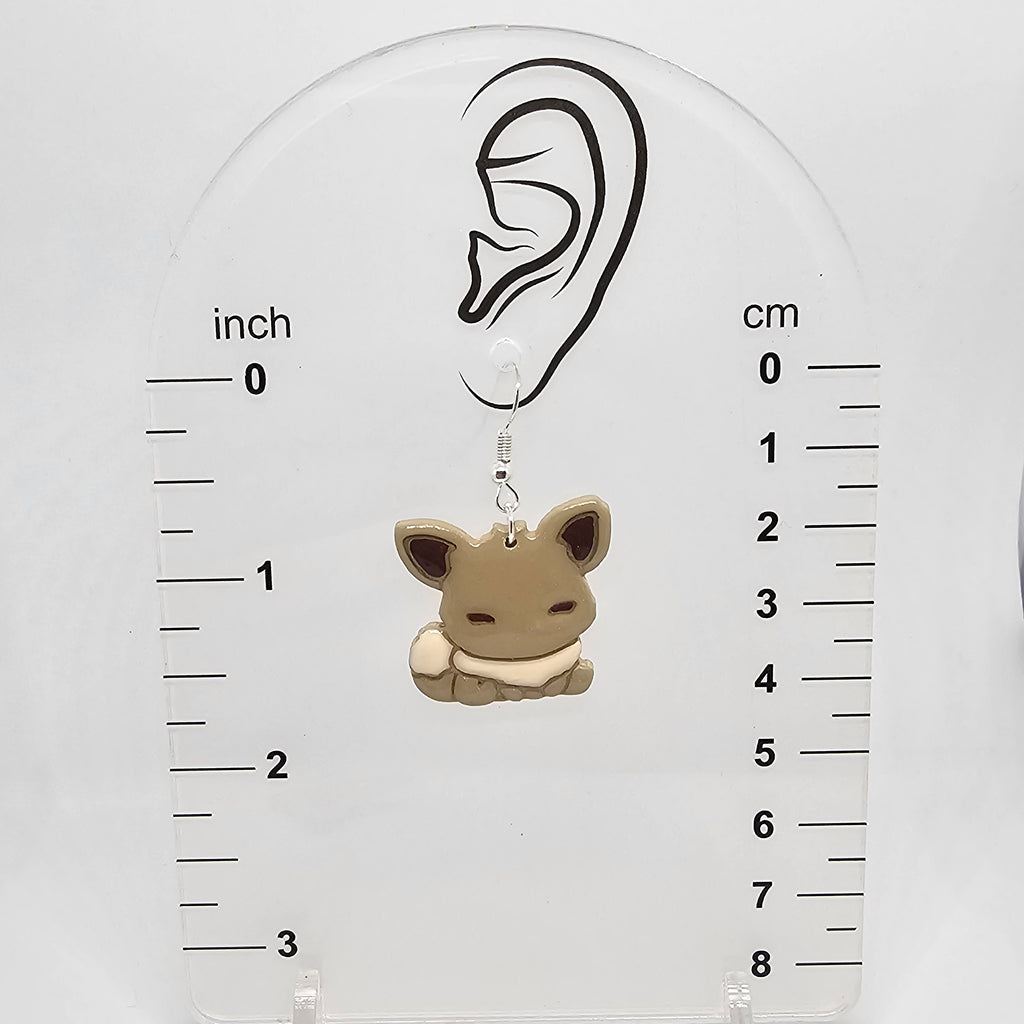 Eevee dangle earring on a measuring device showing it dangles 1.75in from ear lobe hole.