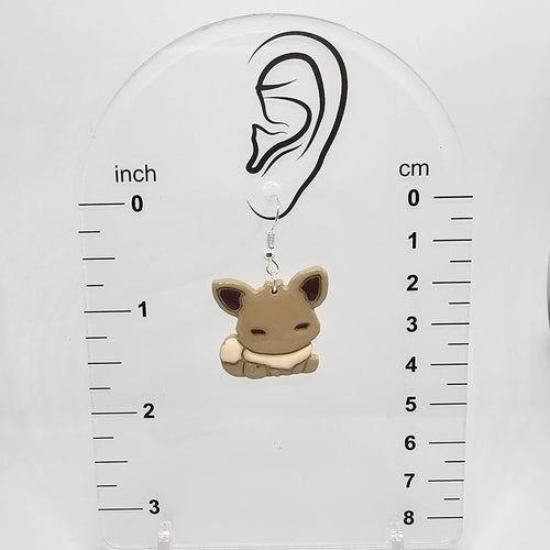 Eevee dangle earring on a measuring device showing it dangles 1.75in from ear lobe hole.