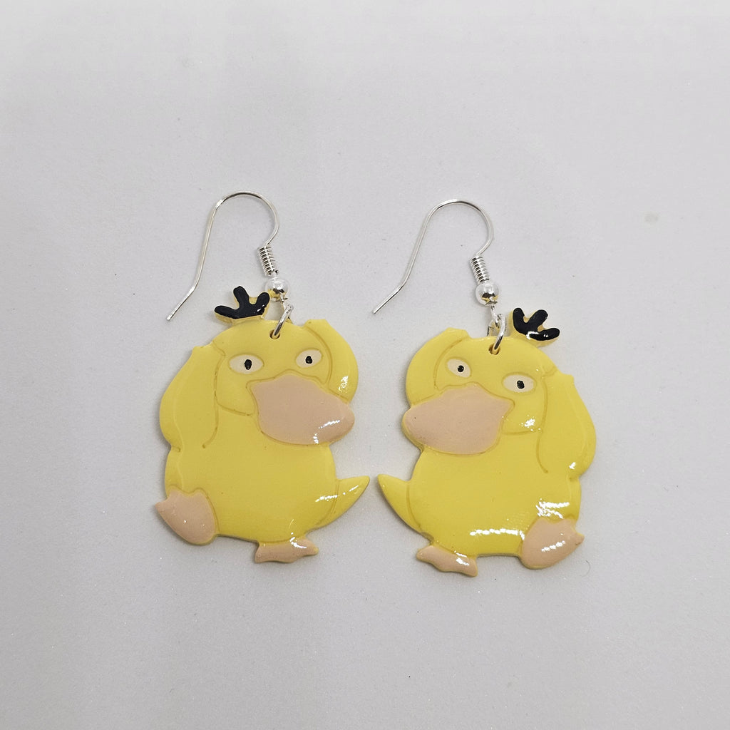 White gold dangle earrings with the Pokemon Psyduck made out of polymer clay