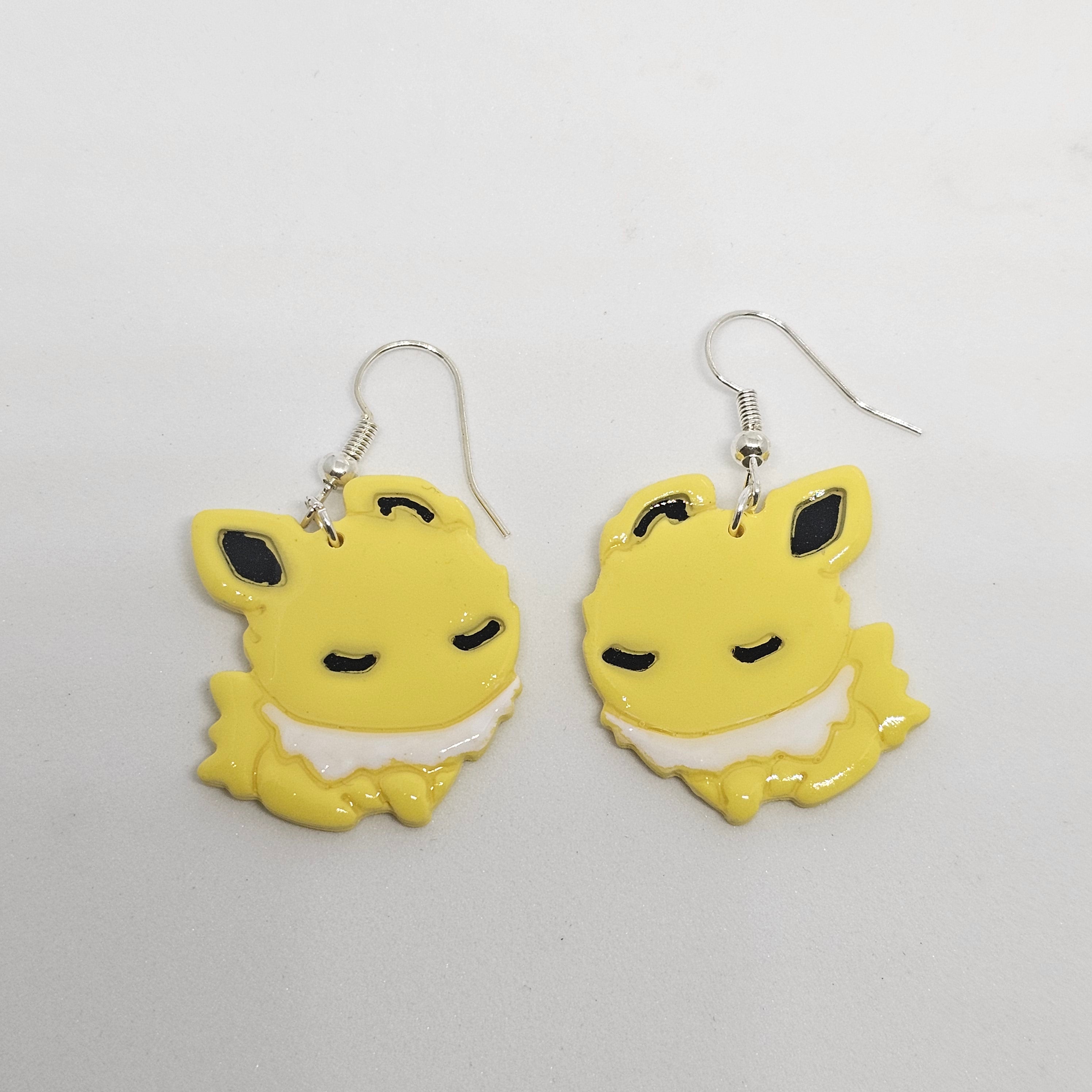 White gold dangle Jolteon pokemon earrings made of polymer clay.