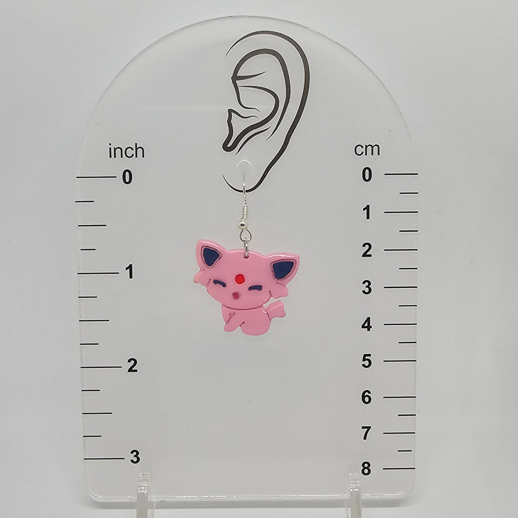 Espeon dangle earrings on and earring measuring device showing they dangle 1.75in from ear lobe. 