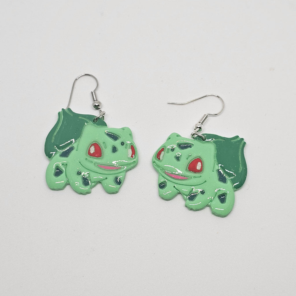 White gold dangle earring with the Pokemon bulbasaur made out of polymer clay. 