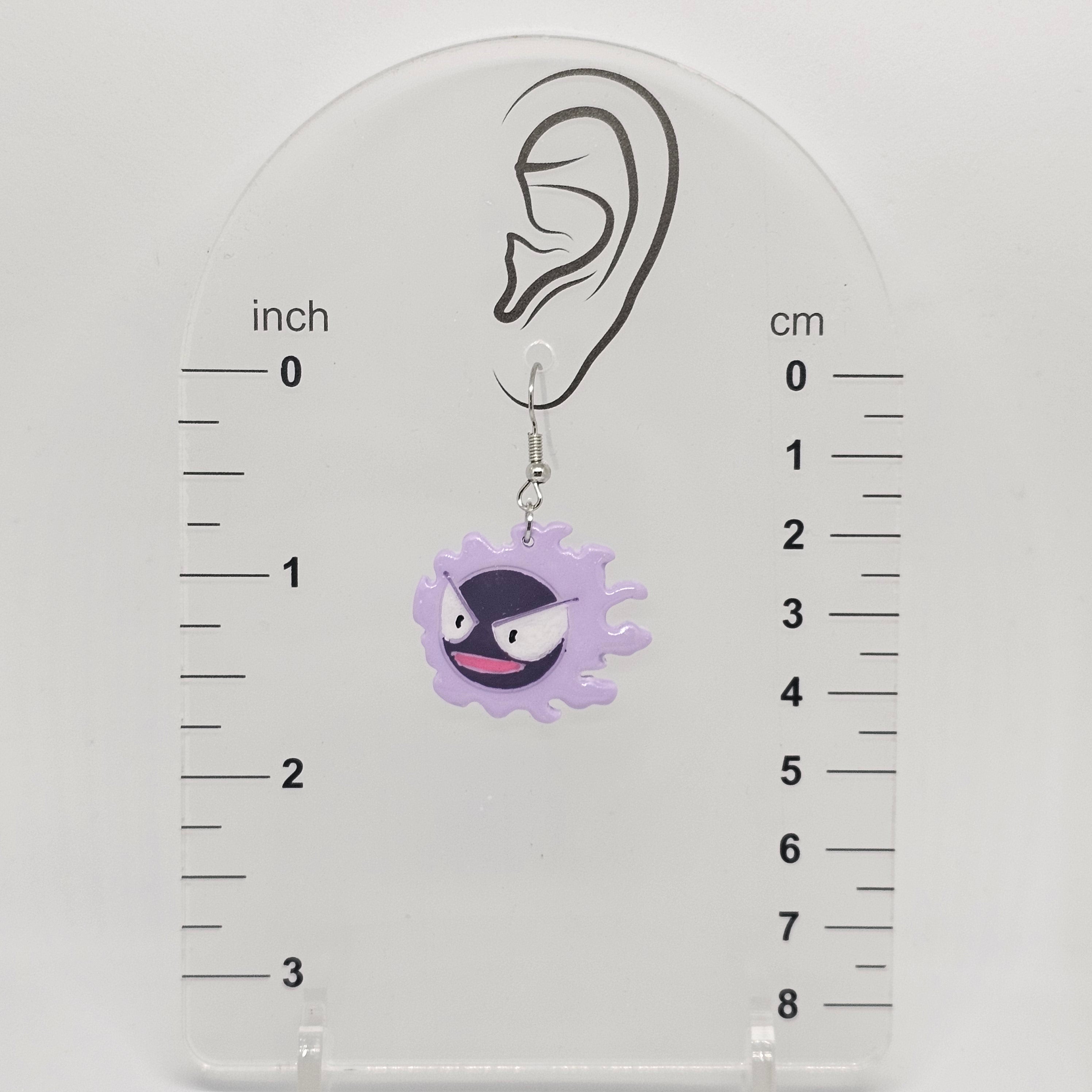Gastly earring dangling on an earring measuring device showing the earring dangle about 1.75 in from ear lobe. 