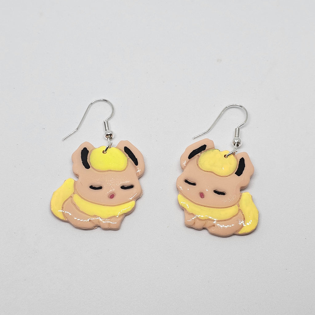 White gold dangle earrings with the pokemon Flareon made out of polymer clay.