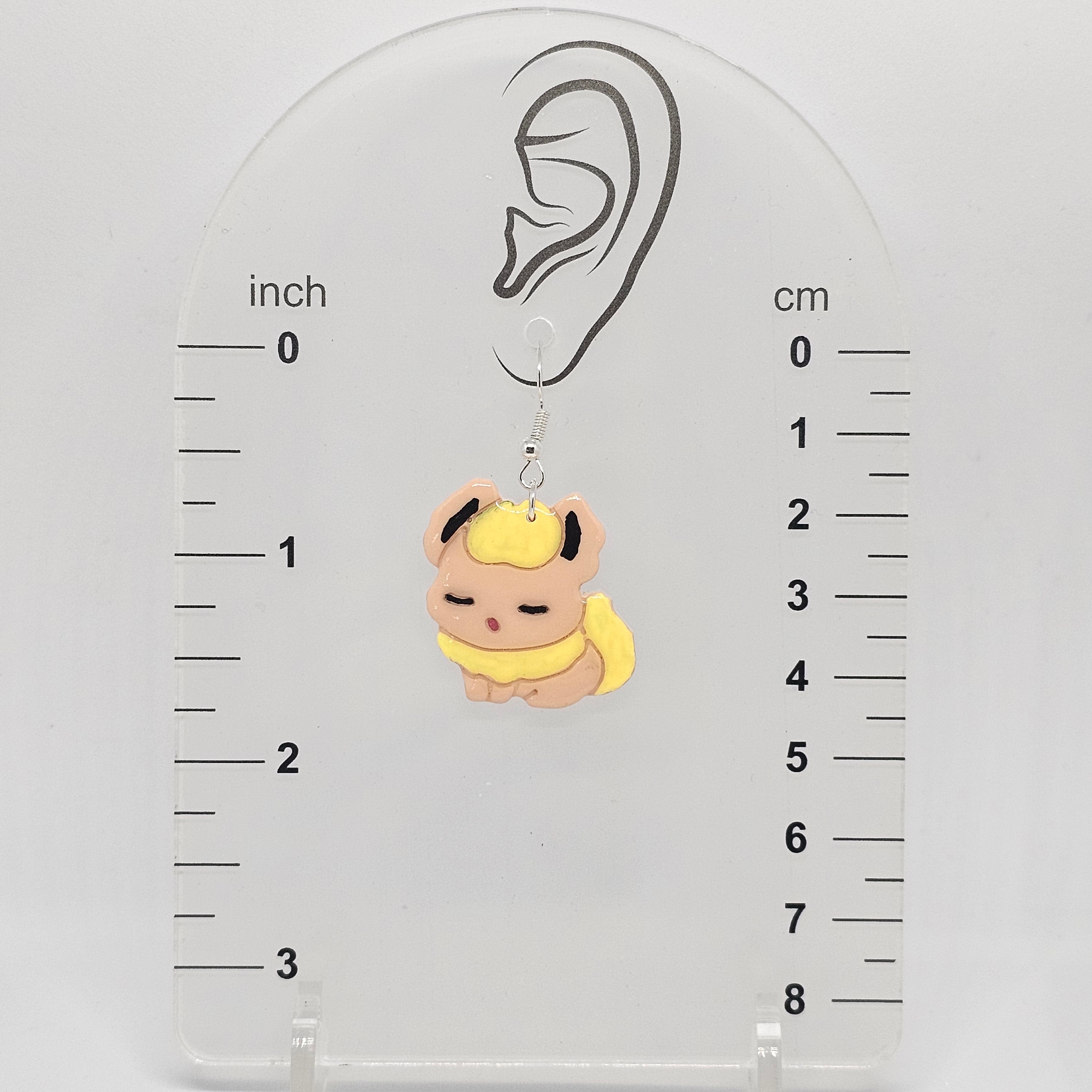 earring on a measuring device showing the flareon earring dangles 1.75in below ear lobe hole.